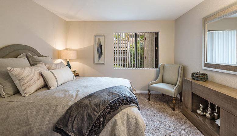 a bedroom with a bed and a desk and a chair