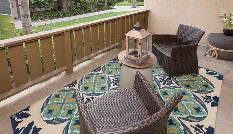 a balcony with two chairs and a table and a lantern