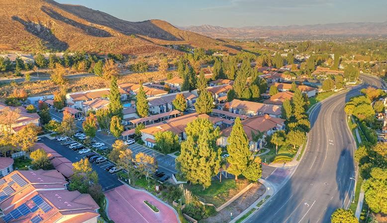 an aerial view of a neighborhood with trees and a road