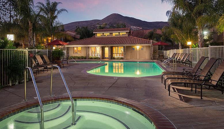 a swimming pool with chairs and a house