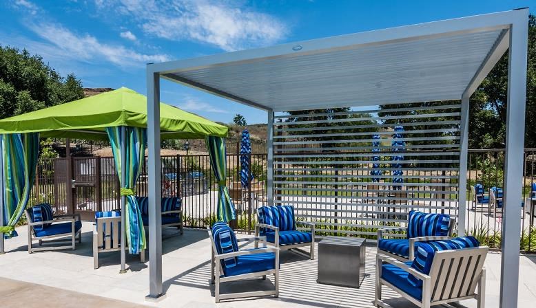 a patio with chairs and umbrellas and a canopy