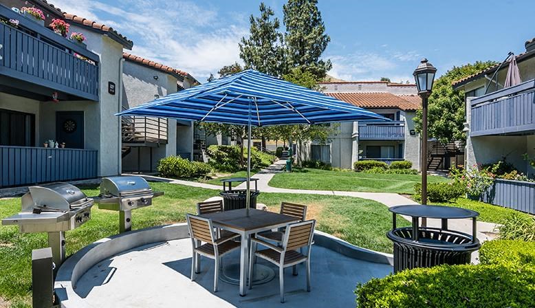 a patio with a table and chairs and an umbrella