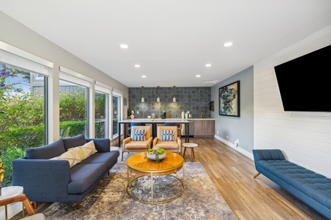 Clubhouse seating area with a blue couch, a coffee table, and a large window.