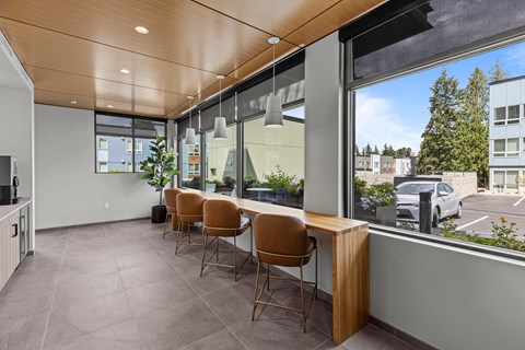 A conference room with a long table and chairs with a view of the parking lot outside.