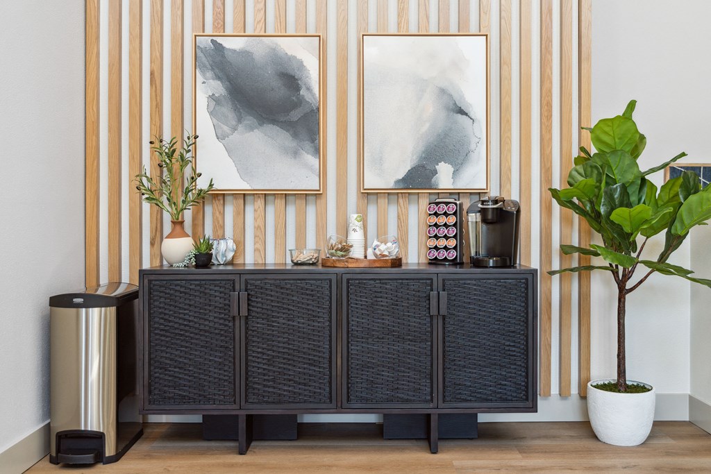 a room with a cabinet with plants and art on the wall