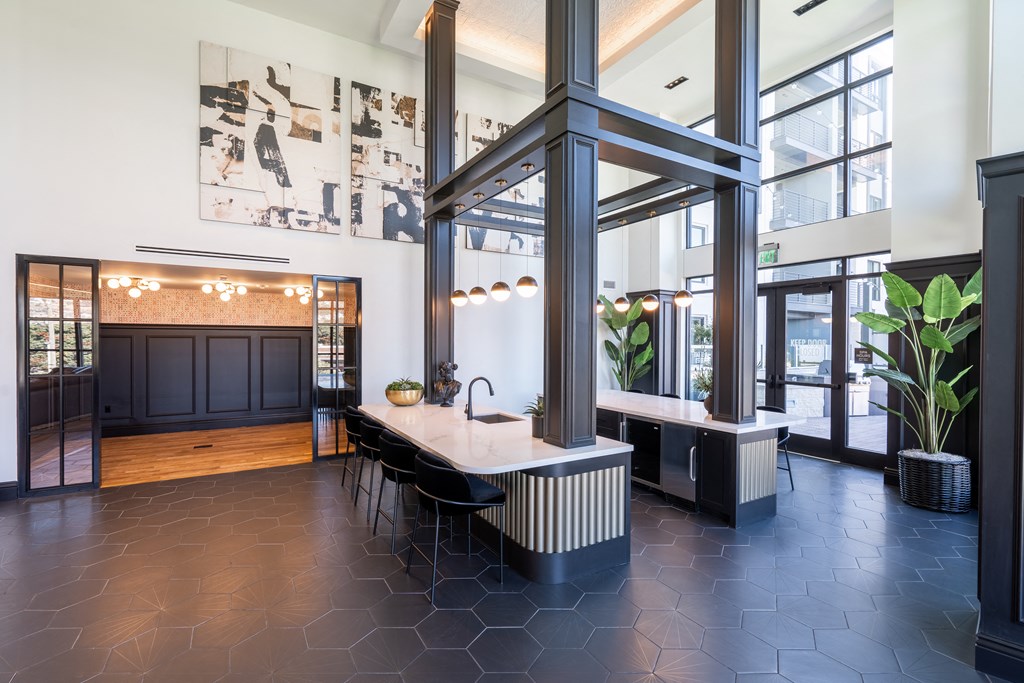 a dining area with a table and chairs in a large room with large windows