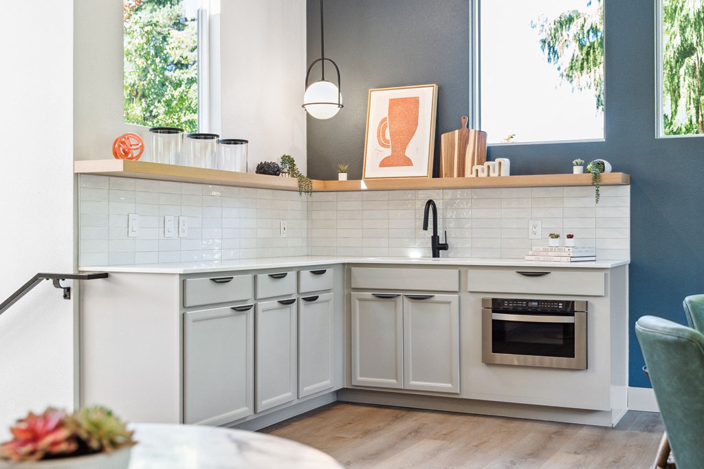 a kitchen with white cabinets and a table