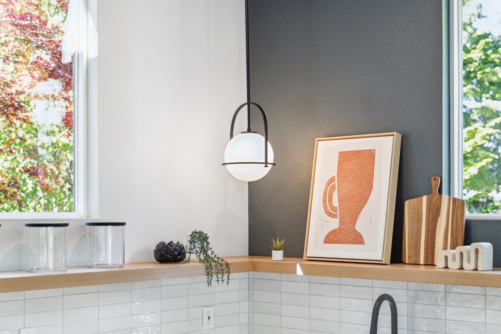 a kitchen with a large window and a counter top with a white and orange picture