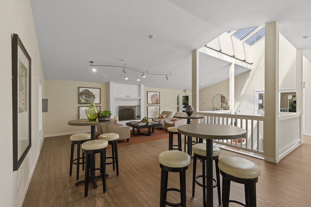 a living room with stools and a bar and a living area with a fireplace