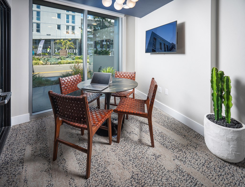 a dining area with a table and chairs and a laptop