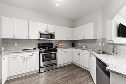 a renovated kitchen with white cabinets and stainless steel appliances