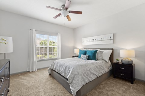 a bedroom with a bed and a ceiling fan