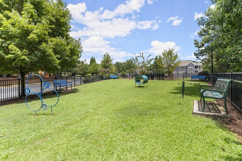 a large grassy park with benches and a playground