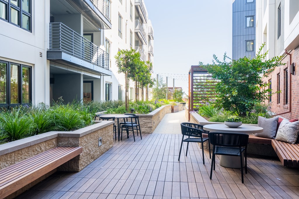 a patio with a table and chairs in an apartment building