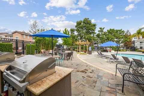 our apartments have a resort style pool and dining area with umbrellas
