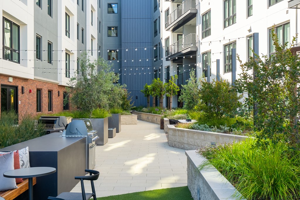 a courtyard with tables and chairs in front of an apartment building