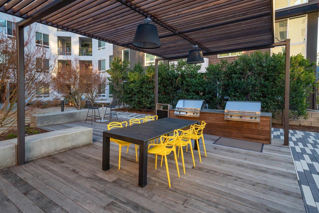 a dining area with a table and yellow chairs