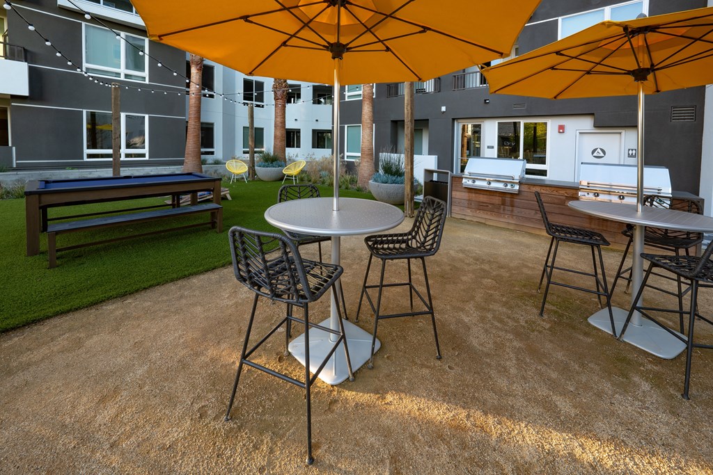 a patio with tables and chairs and umbrellas