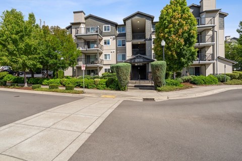 A large apartment building with a tree in front of it.