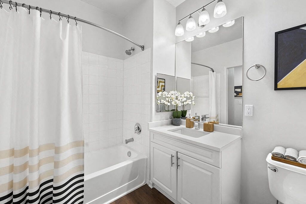 a white bathroom with a shower and a sink