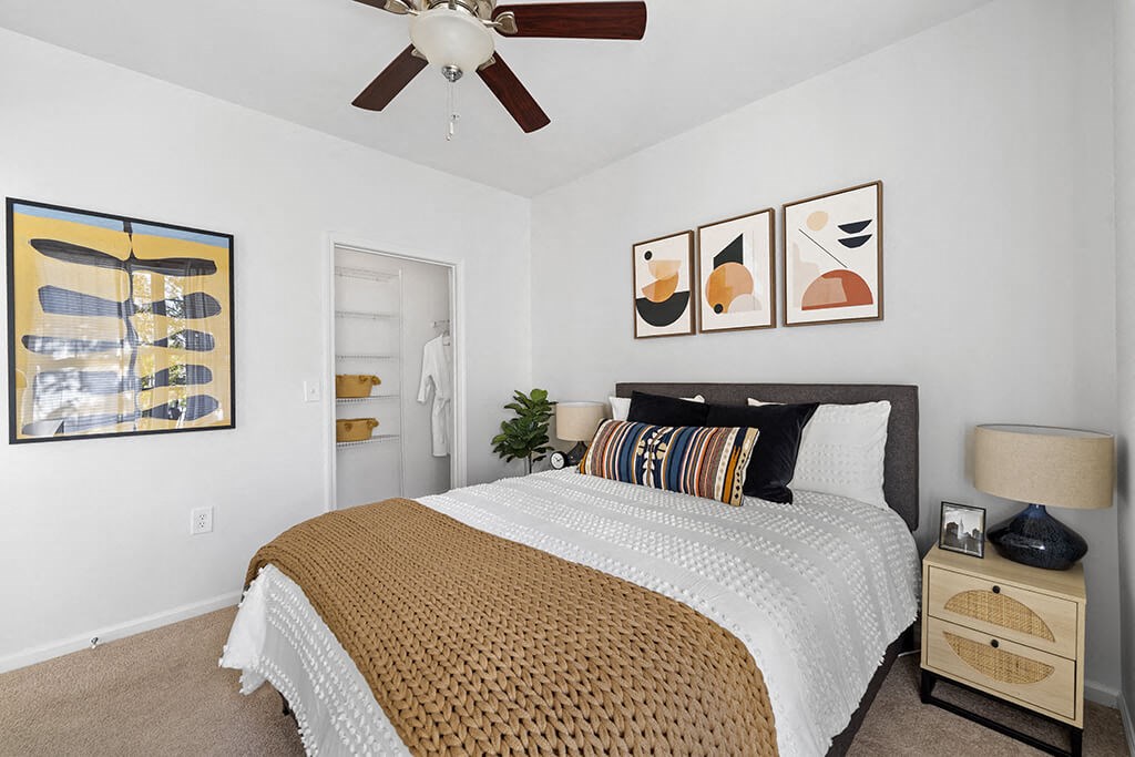 a bedroom with a bed and a ceiling fan