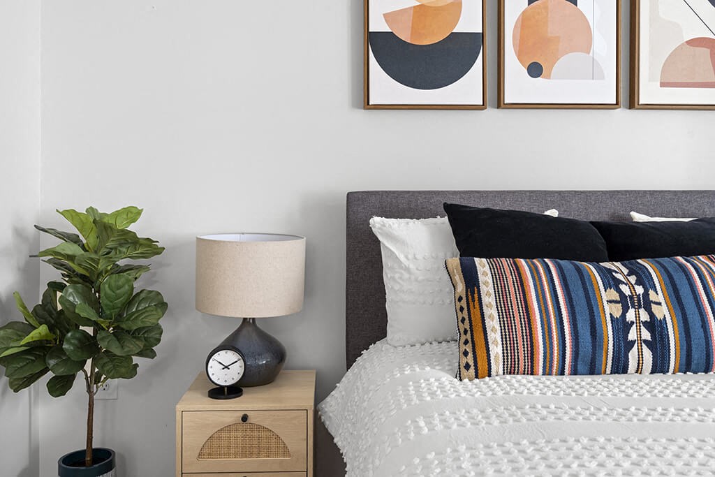 a bedroom with a bed and a clock on a night stand