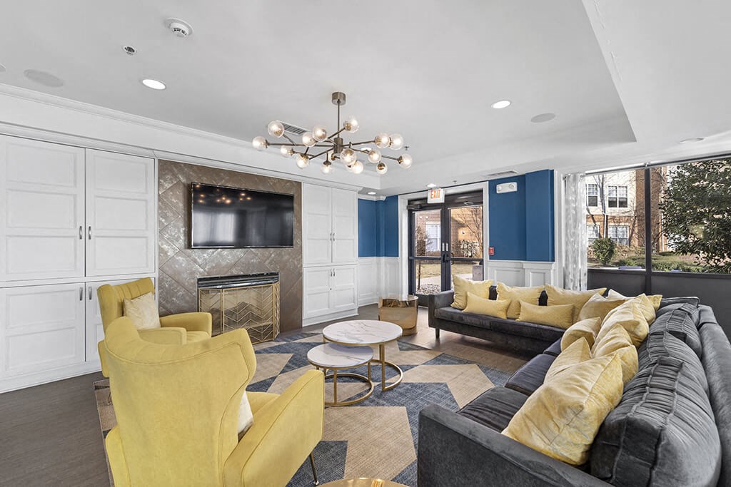 a living room with blue and yellow furniture and a television