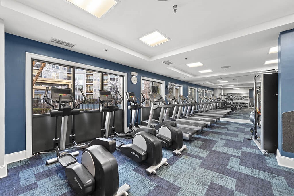 a gym with cardio equipment and a row of cardio machines