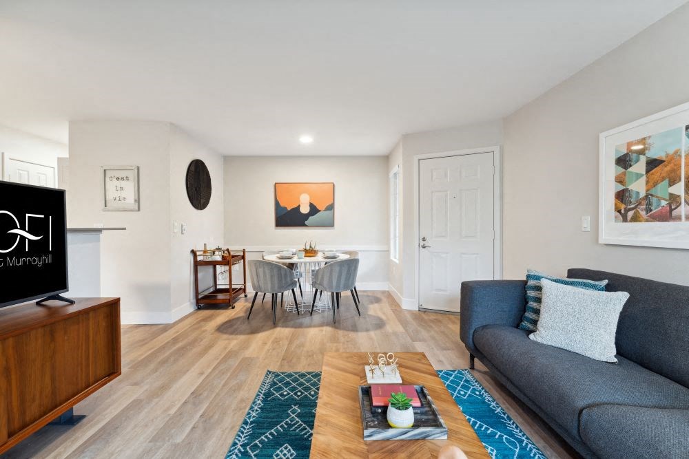 A living room with a grey couch and a coffee table in front of it.