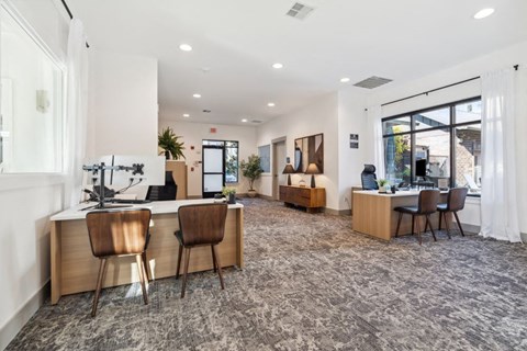 a conference room with a desk and chairs and a window