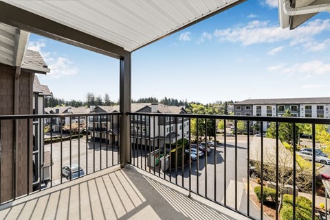 A balcony overlooks a parking lot and a residential area.