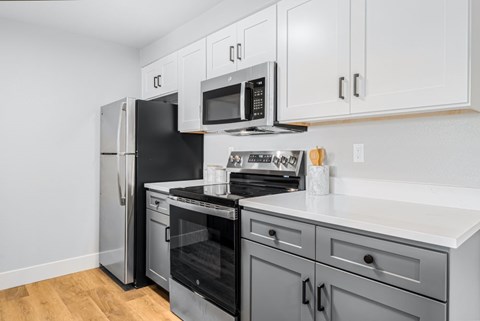 A kitchen with black appliances and white cabinets.