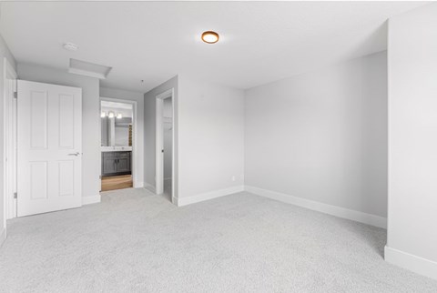 A white room with a carpeted floor and a light on the ceiling.
