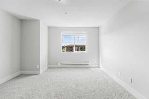 A room with a window and a radiator on the floor.