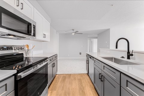 A modern kitchen with a black stove top oven and a black microwave above it.