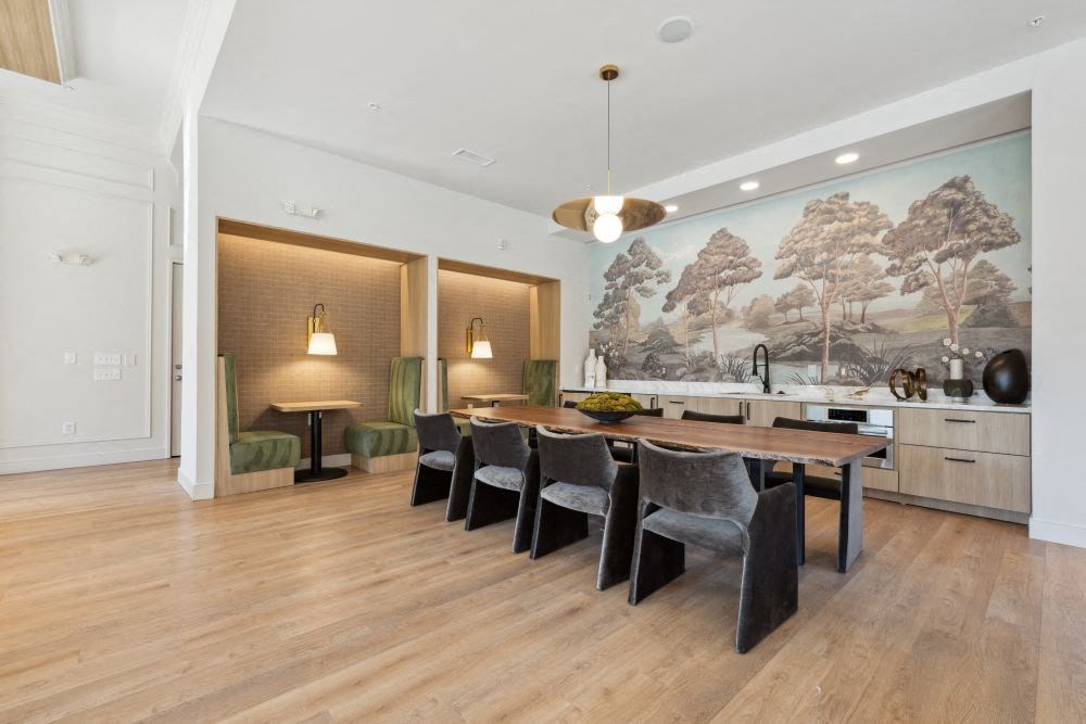 a dining room with a table and chairs and a painting on the wall