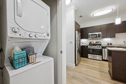 a laundry room with a washer and dryer and a kitchen