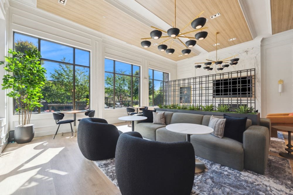 a living room with a couch and tables and large windows