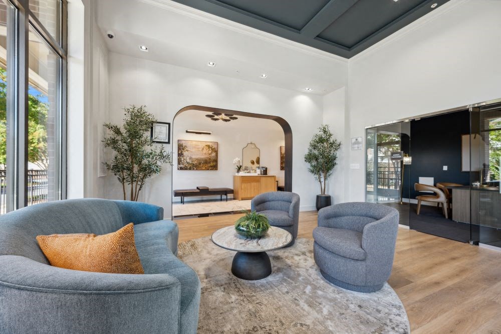 a living room with blue chairs and a rug