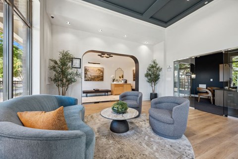 a living room with blue chairs and a rug