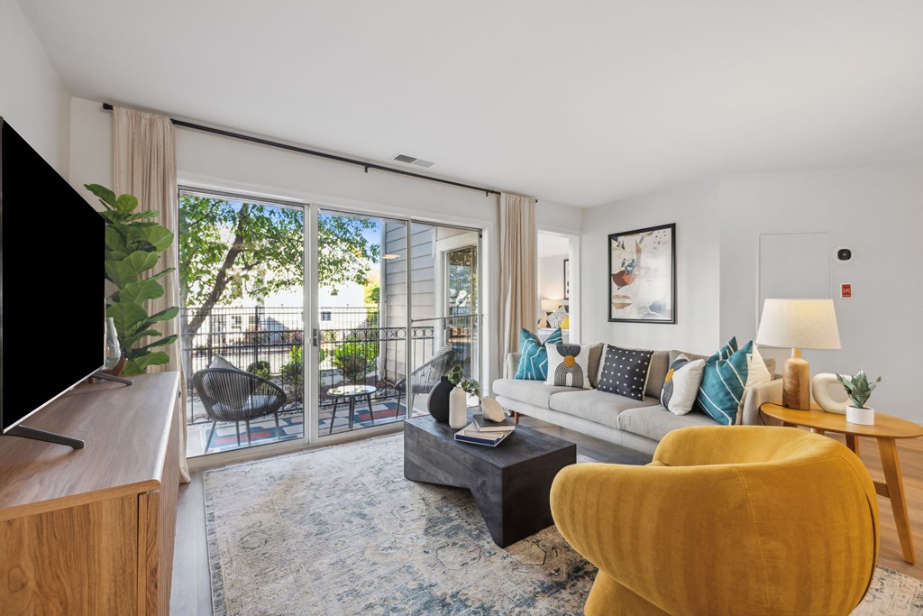 a living room with a couch and a tv and a balcony