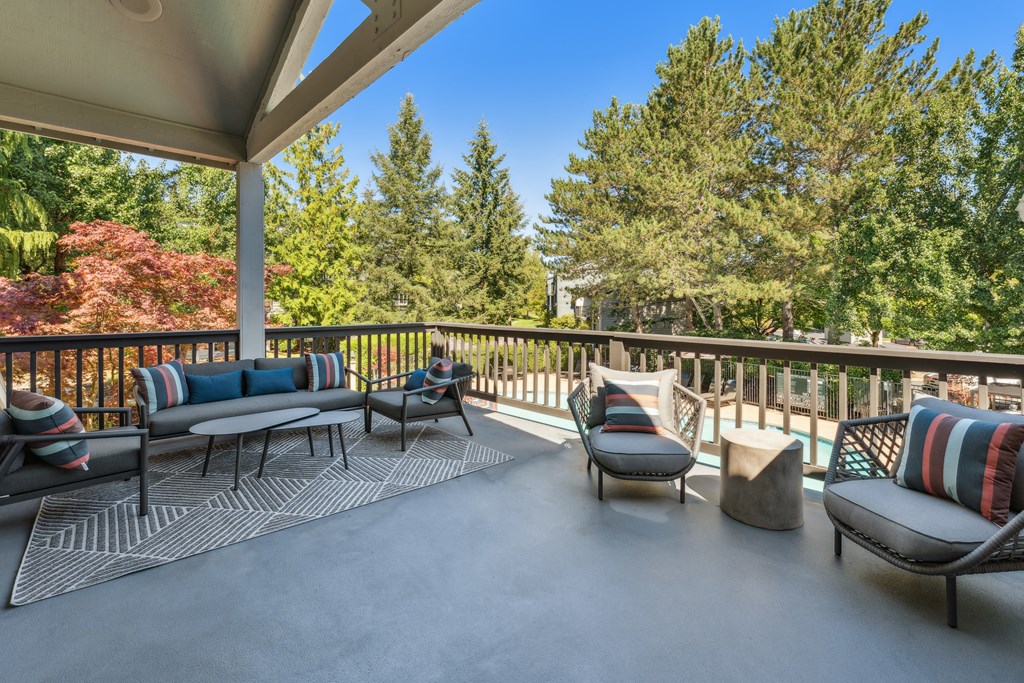 a patio with couches and chairs and trees