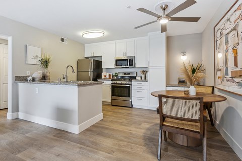a kitchen and dining room with a table and a ceiling fan