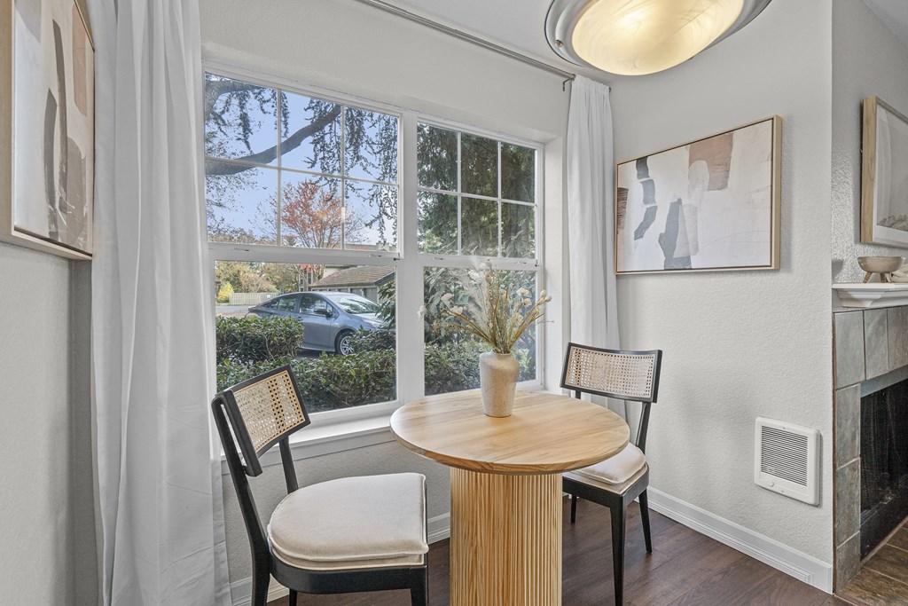 a dining room with a large window and a table and chairs