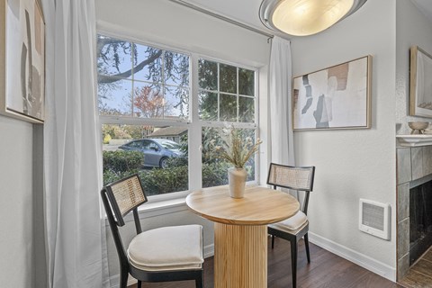 a dining room with a large window and a table and chairs