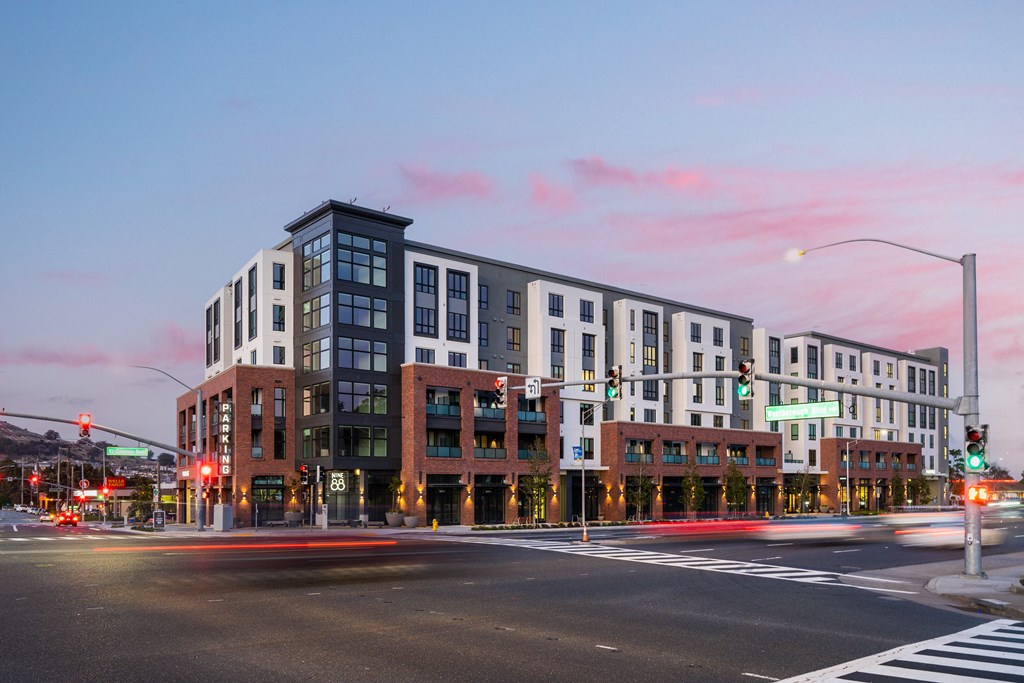 a building on the corner of a city street at dusk