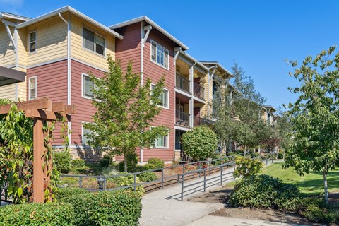 an apartment building with a walkway and trees in front of it