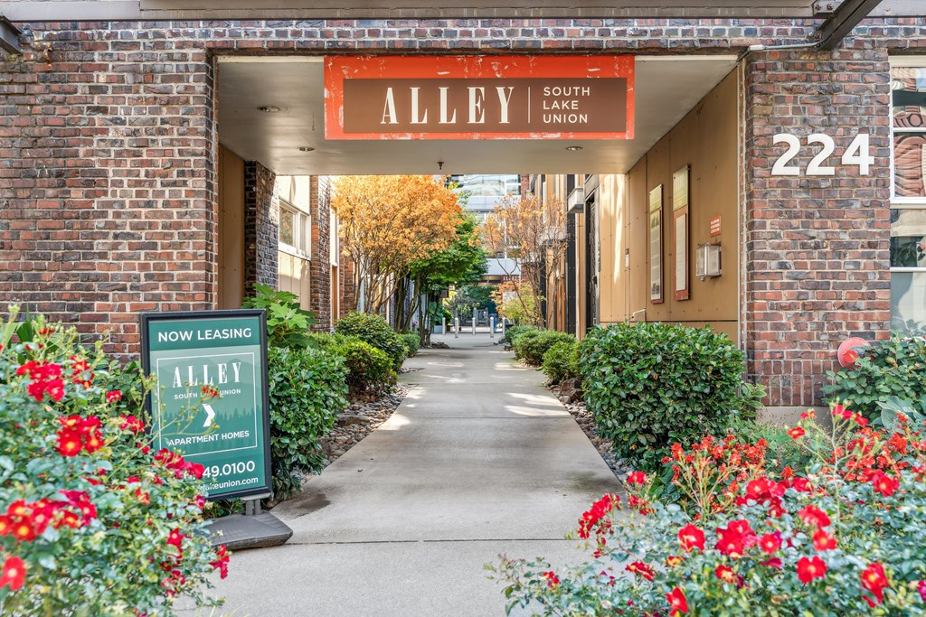a walkway leading to a building with a red sign