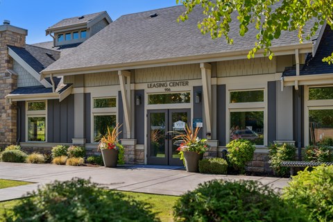 the front of the bloom center building with a sidewalk and potted plants