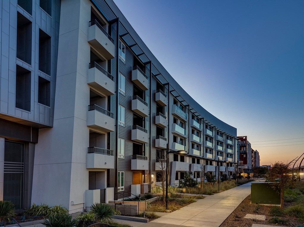 modern residential building with a sidewalk in front of it